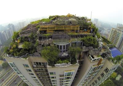 　　昨日，身穿橘黃色馬甲的工作人員在人濟(jì)山莊樓頂拆除違章建筑。新京報(bào)記者 吳江 攝