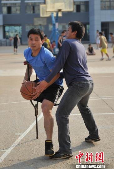 圖為拄著拐杖的瞿詩(shī)濤和同學(xué)搶球。劉占昆攝
