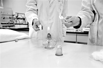 實驗人員操作的燃燒檢測法中，真蠶絲離開火焰就熄滅(左)。