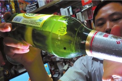 這瓶未開(kāi)封的燕京啤酒內(nèi)有一顆黑色懸浮物。京華時(shí)報(bào)記者 徐曉帆 攝