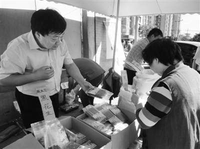 昨日，河南企業(yè)家劉春喜在京“練攤”，為顧客挑選綠豆。新京報(bào)記者 張玉學(xué) 攝