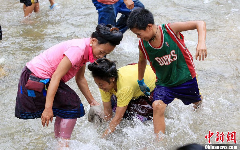 7月9日，村民在小河里摸魚搶魚。譚凱興 攝