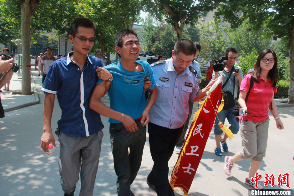 圖為獲救嬰兒父親情緒一度失控，當(dāng)?shù)鼐焦ぷ魅藛T對(duì)其進(jìn)行攙扶。張一辰 攝