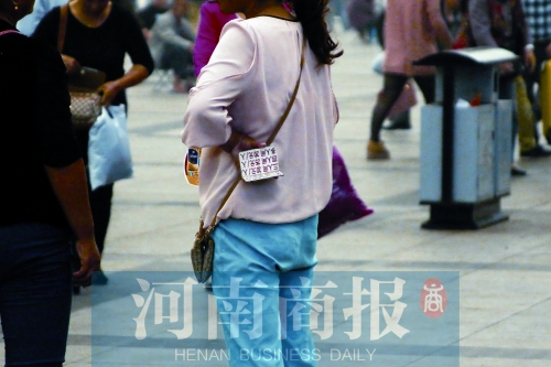 火車站廣場(chǎng)，一女子拿著寫有不同房型價(jià)位的卡片在拉客，不少市民抱怨，受過此類“騷擾”