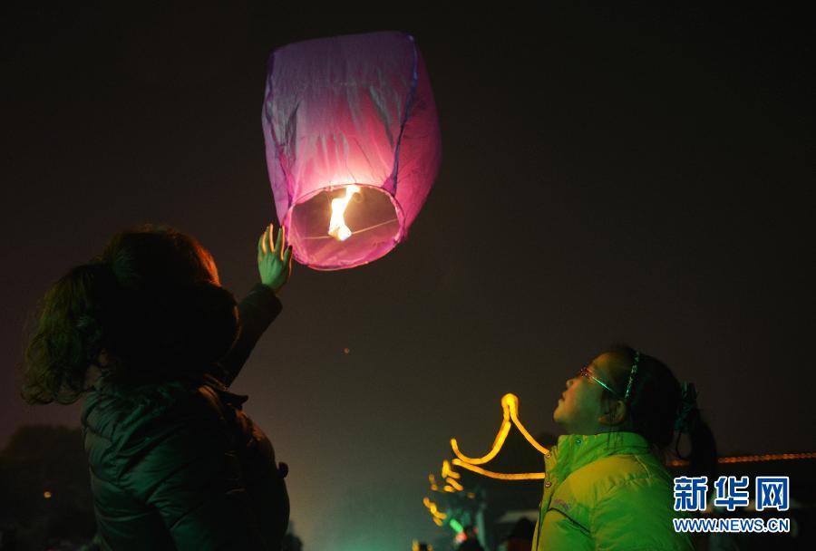 　1月30日，游客在江蘇省鎮(zhèn)江市金山公園門口放飛孔明燈。