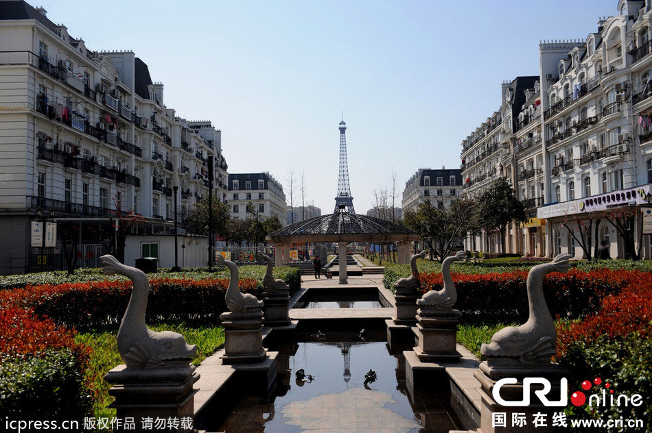 　2014年3月21日，杭州天都城，農(nóng)民在山寨埃菲爾鐵塔下耕作。圖片來源：東方IC