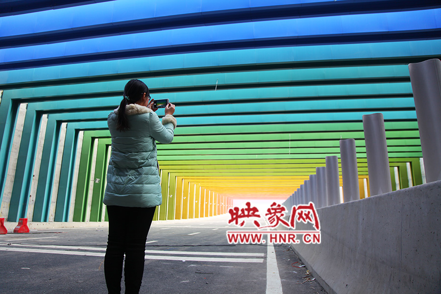 一女孩拿出手機(jī)拍照。