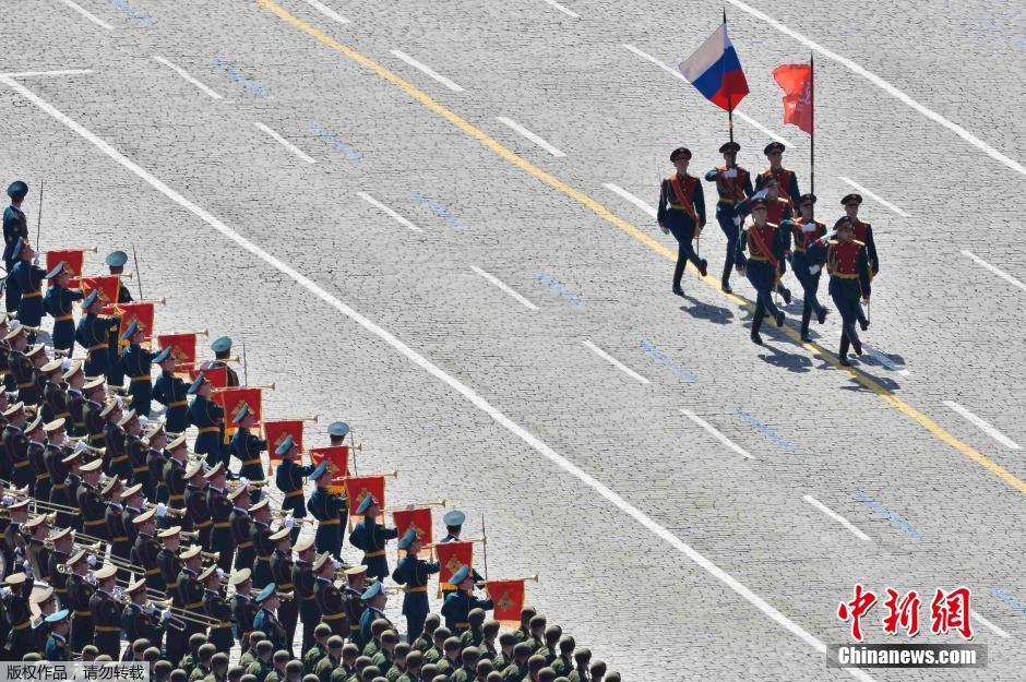 圖為俄羅斯國(guó)旗從受閱部隊(duì)前經(jīng)過(guò)。