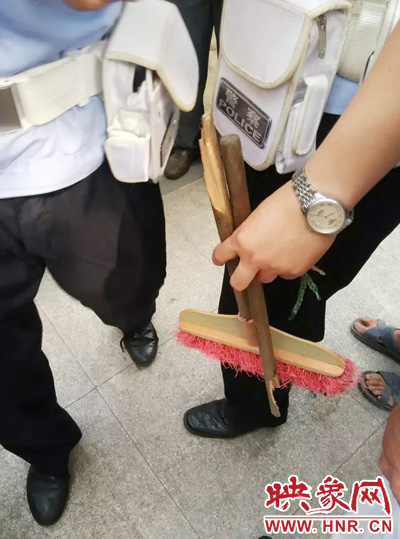 老太從環(huán)衛(wèi)工手中奪過掃帚，用腳踩斷，用力向環(huán)衛(wèi)工人的手上和腿上敲去。