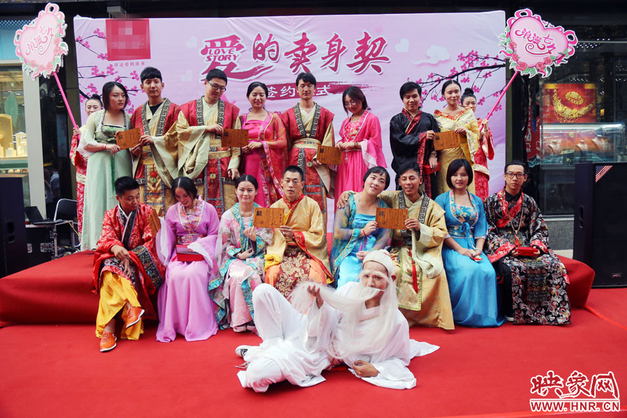 現(xiàn)場8對兒年輕男女舉起“賣身契”集體拍照。