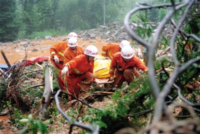 昨日，消防隊員在四川省都江堰市中興鎮(zhèn)三溪村滑坡現(xiàn)場運送遇難者遺體。新華社記者 薛玉斌 攝