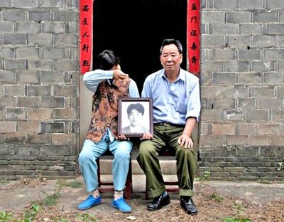 江蘇鎮(zhèn)江，老劉夫婦捧著獨(dú)生子的遺像在老家前留影南方都市報(bào)供圖L