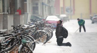 小伙子跪在樓前，一直抬頭看著樓上。 孫立國/攝