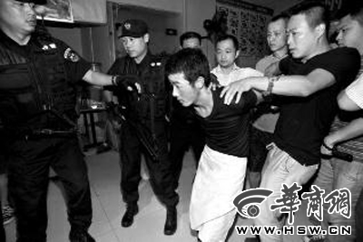 犯罪嫌疑人韓牙某圍著圍裙在廚房?jī)?nèi)拉面，被民警抓獲 本報(bào)記者 鄧小衛(wèi) 攝