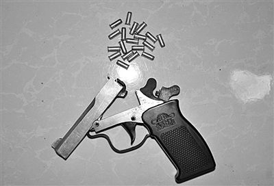 警方從搶劫嫌疑人處起獲的贓款和發(fā)令槍、子彈。警方供圖