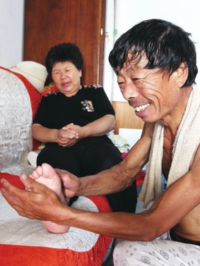 慈成富為老伴按摩。