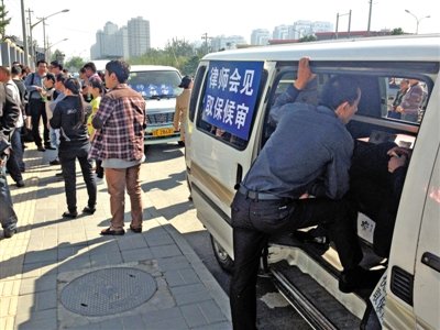 昨日，朝陽區(qū)看守所門前有人排隊(duì)。大門外還停有多輛寫有“律師會(huì)見”字樣的車。