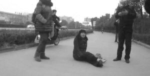 鄭大姐坐在地上，警方趕到進(jìn)行施救。（視頻截圖由警方提供）