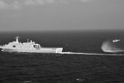 11日，抵達馬航飛機失聯(lián)海區(qū)的海軍井岡山艦與艦載直升機協(xié)同展開立體搜救行動。新華社發(fā)