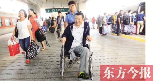 李剛手術(shù)后歸來，在車站工作人員幫助下走出鄭州火車站站臺  東方今報首席記者 張曉冬 攝