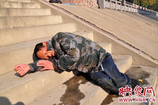 這名男子的衣服以及褲子全濕透了，水從衣褲里流出來，嘴里散發(fā)著濃烈的酒氣。