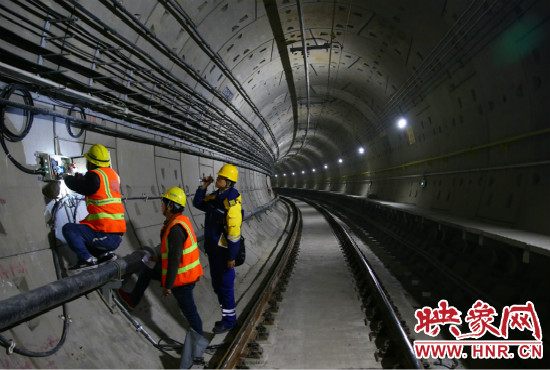 設(shè)施設(shè)備部通號室信號專業(yè)工程師正帶領(lǐng)著同事們進行軌道信號轉(zhuǎn)轍機零件更換。