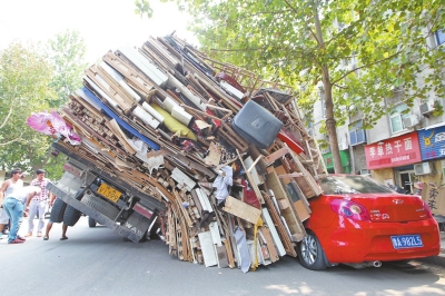 紅色小轎車被砸，卡在路邊動彈不得。
