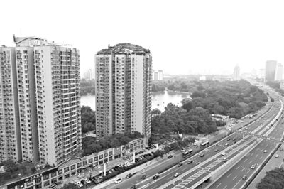 昨日，人濟(jì)山莊小區(qū)，與其他樓相比，B棟樓頂層天臺上違規(guī)建造了一棟兩層小樓，假山大樹俱全。新京報記者