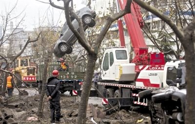 輸油管道爆炸后，搶修人員將被炸毀的車輛運(yùn)出現(xiàn)場(chǎng)。