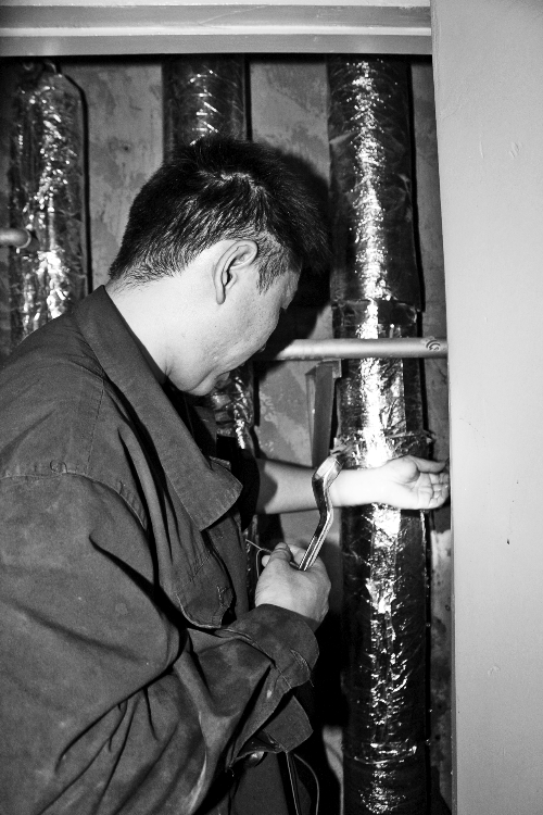 苗師傅一邊進(jìn)行維修，一邊用耳機(jī)接聽市民的電話。