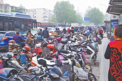 省人民醫(yī)院北門，路邊的公交站牌處停滿非機動車，上、下客只能在快車道上。