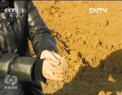 麻剛沙系麻剛石粉碎而成。記者找到一塊麻剛石，一捏就碎成粉末，硬度非常差。央視截圖