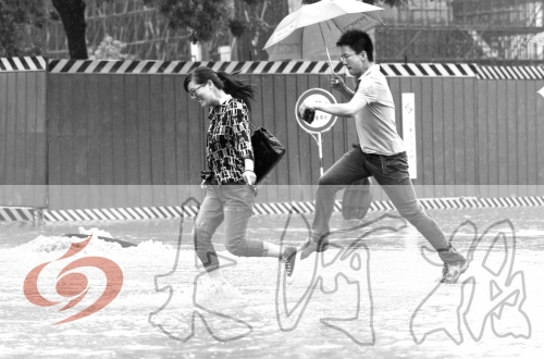 鄭州經(jīng)三路與北環(huán)交叉口處，積水較深，行人們不得不“練輕功”。 記者 白周峰 攝影