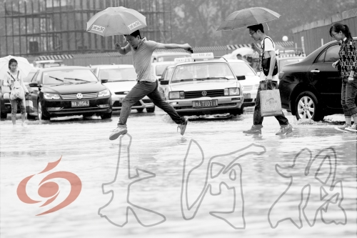 鄭州經(jīng)三路與北環(huán)交叉口處，積水較深，行人們不得不“練輕功”。 記者 白周峰 攝影