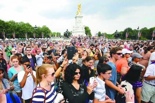 7月23日，在英國倫敦白金漢宮外，民眾們爭相閱讀“王室寶寶”出生的正式公告。