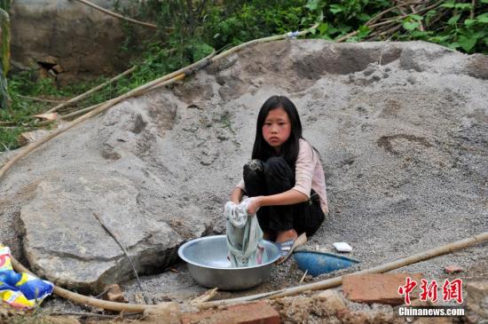 8月9日，云南巧家紅石巖村，10歲的劉鑫蕊在洗自己的衣服