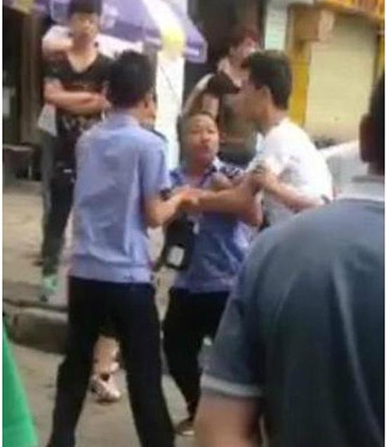 付某（右）與城管執(zhí)法人員廝打在一起。