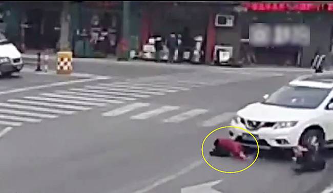 圖為小姑娘被卷進(jìn)車輪下瞬間。