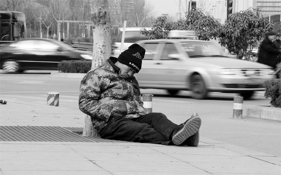 2月2日，鄭州市中州大道農(nóng)業(yè)路立交橋下，50歲的王文德打算在臨近春節(jié)前再接些零活兒，由于疲憊，他睡著