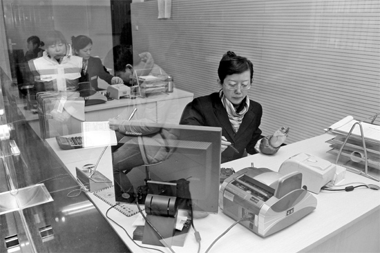 2月16日，鄭州市自來水總公司鄭東新區(qū)一營業(yè)廳，柜臺內(nèi)工作人員正在為市民辦理業(yè)務(wù)