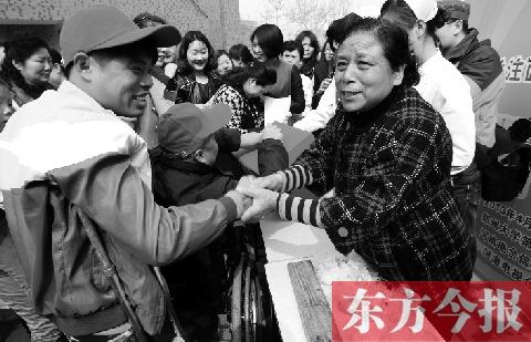 昨日，鄭大四附院的大樓前，“面人鄭”鄭玉芬（右）向前來(lái)捐款的殘疾人表示感謝