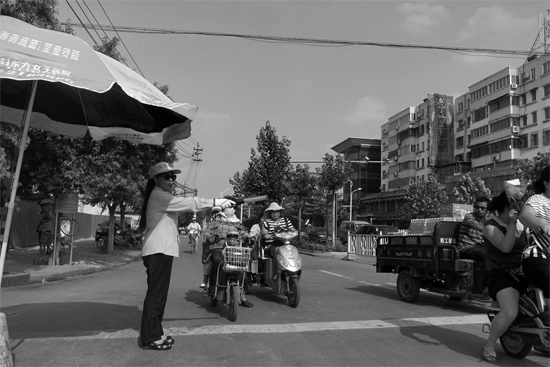 昨日，開封市區(qū)一名協管員在指揮群眾過馬路