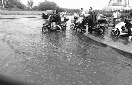 8月7日，鄭州一場暴雨，鄭州多處干道被淹，市民行路如過河