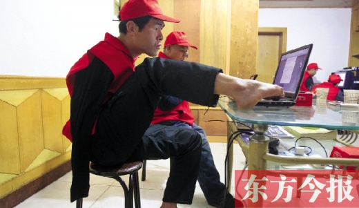 12月2日，一名“豫殘聯(lián)盟”志愿者正通過網(wǎng)絡(luò)、微博等聯(lián)絡(luò)著各地殘疾人朋友 東方今報首席記者 張曉冬