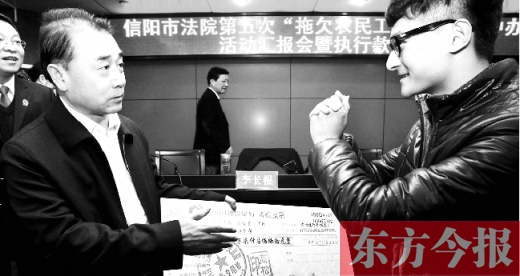 張立勇將依法執(zhí)行回來的農(nóng)民工工資發(fā)放給案件當事人游昌華，游昌華施以中國傳統(tǒng)作揖禮答謝