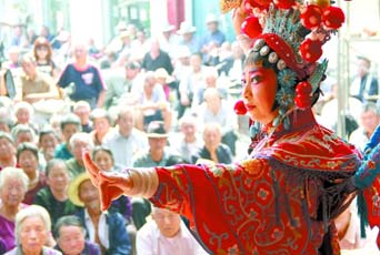 圖為8月15日戲曲演員在“流動舞臺車”上表演傳統(tǒng)地方戲《穆桂英下山》。