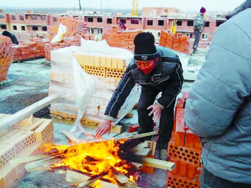 在俄羅斯工地打工時(shí)，因?yàn)樘焯?，工人不得不在工地生火取暖。（圖由方先生提供）