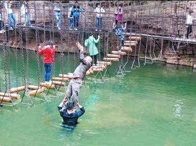 中年男游客正踩著景區(qū)安全員郭小明的肩膀過河。網(wǎng)友“@我的小名叫張孩”供圖