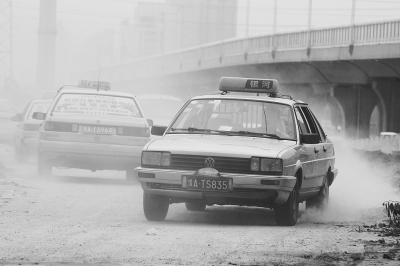 施工的道路上，車輛通過塵土飛揚(yáng)。