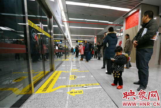 小朋友在等候區(qū)內(nèi)等待地鐵。